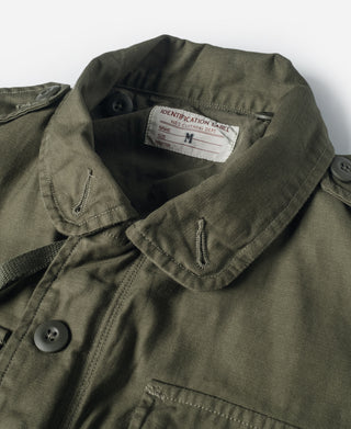 Olive field jacket collar with snap button placket and size label at neckline