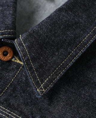 Selvedge denim jacket seam and V-stitch detail with brown button at placket