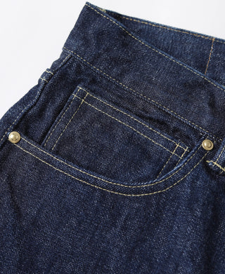 Indigo denim jeans back pocket with curved yoke seam and metal button, close-up