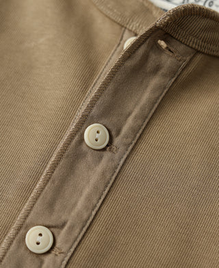 Khaki henley button placket with two visible round buttons and seam stitching