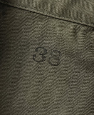 Olive jacket fabric detail with 3B embossed stamp