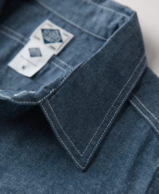 Blue chambray shirt tag and stitched trim detail near collar