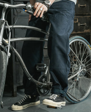 Navy deck pants on a wearer, featuring cargo pockets and buttoned cuffs at hem.