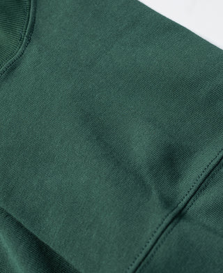 Green T-shirt shoulder and sleeve seam detail, short sleeves and smooth fabric.