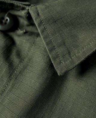 Close-up of olive jacket fabric and stitched collar edge with button