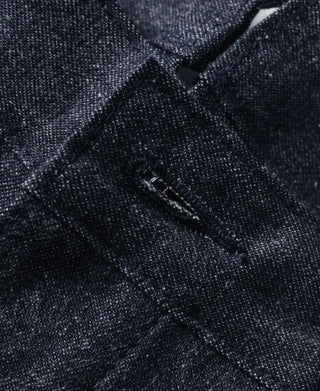 Close-up of dark navy denim front seam and fly hardware detail