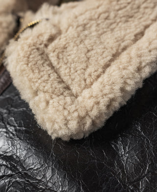 Tan shearling-lined collar close-up on dark brown leather flight jacket