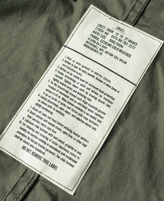 Olive green parka care label stitched on the inside chest area