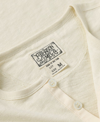 Cream slub cotton henley T-shirt neckline with small chest label and two-button placket