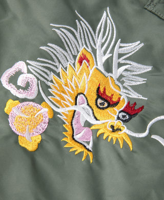Close-up of embroidered tiger-and-dragon design with white and colorful thread on olive fabric