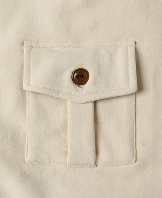 Apricot chest pocket detail with stitched flap and brown button closure