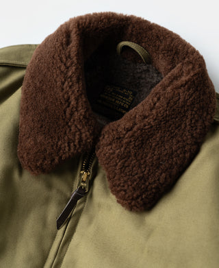 Khaki flight jacket close-up of brown shearling collar and zipper hardware at center front.