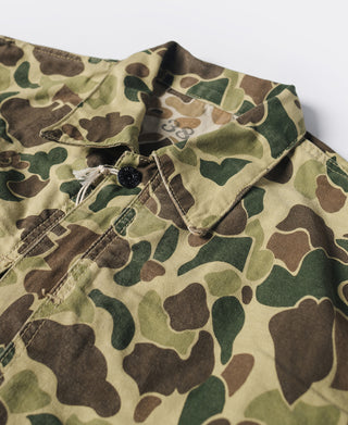 Close-up of camouflage jacket fabric with buttoned collar and stitch details