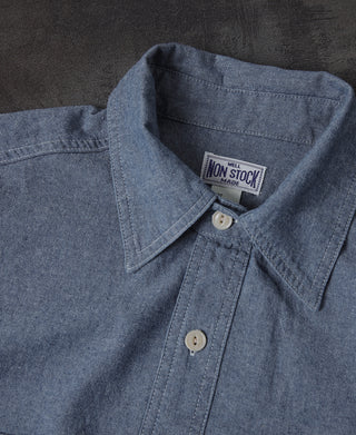 Blue chambray shirt collar close-up with button-down tab and placket