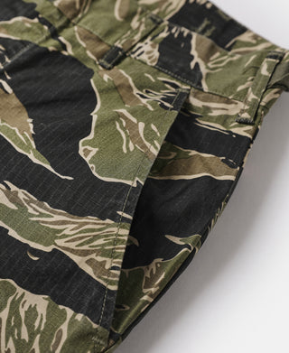 Tiger stripe camo fatigue pants side view with stitched panel and cargo pocket.
