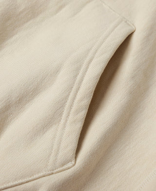 Apricot hoodie fabric close-up with smooth knit texture.
