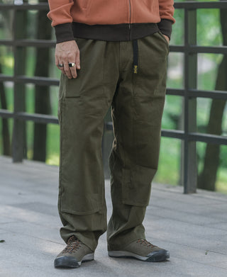 Olive climbing pants on model with cargo-style side pockets