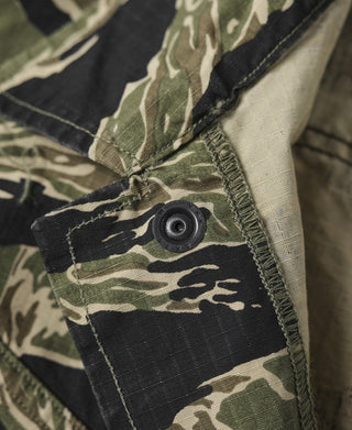 Camo jacket sleeve placket with dark button and reinforced topstitching.