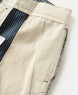 Cream striped work pants, front leg panel with vertical seam and pocket edge