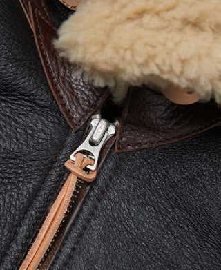 Dark brown leather flight jacket with tan shearling trim and front zipper pull