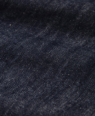 Indigo selvedge denim fabric texture with visible weave and faint whisker creases