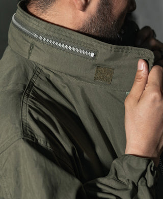 Olive parka neckline with zipper, inner drawcord, and side fabric panel.