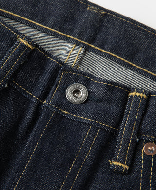 Indigo denim jeans fly area with metal button and layered stitch seams