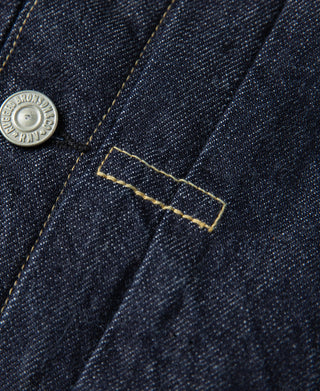 Close-up of indigo denim placket with contrast yellow stitching and metal button