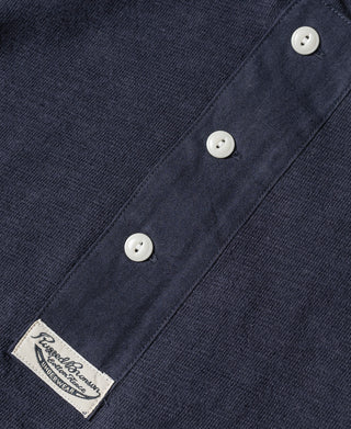 Navy henley T-shirt with three white buttons and brand label