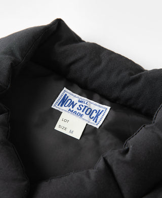 Black quilted vest interior label and padded collar area.