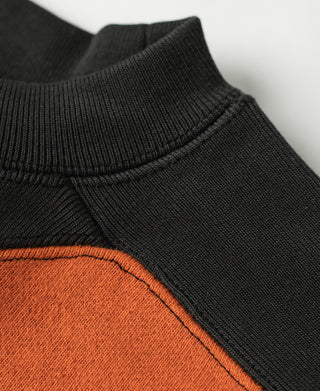 Ribbed black turtleneck style collar on orange-and-dark two-tone sweatshirt.