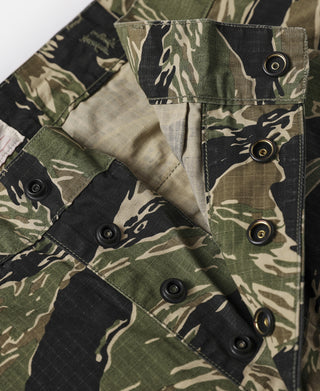 Tiger stripe camo fatigue pants with cargo flap and three round snap buttons.
