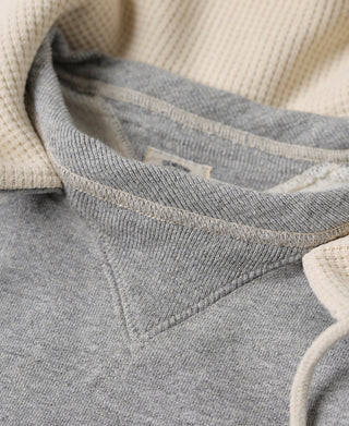Gray terry hooded sweatshirt interior showing cream lining and knit trim