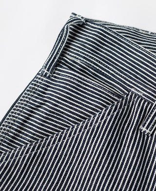 Striped carpenter pants front panel with button fly and tailored pocket seam detail.