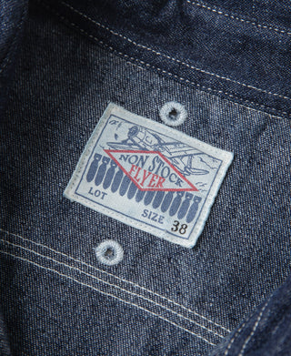 Denim workshirt interior label on dark blue fabric near button area