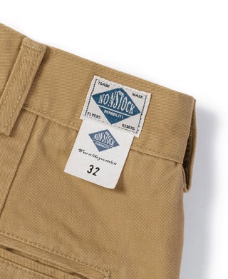 Yellow chino waistband label and size tag on pleated trouser front