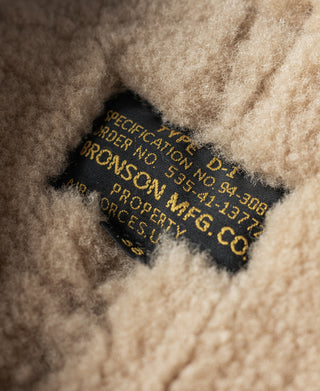 Inside label on tan shearling lining of dark brown flight jacket