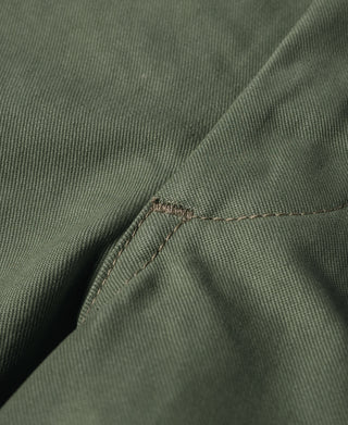 Olive trousers close-up of pocket edge with reinforced stitching at seam