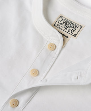White henley shirt front close-up with cream buttons and Bronson Mfg Co label