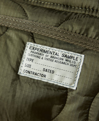 Close-up label on olive waist bag liner fabric, sample and contract text tag