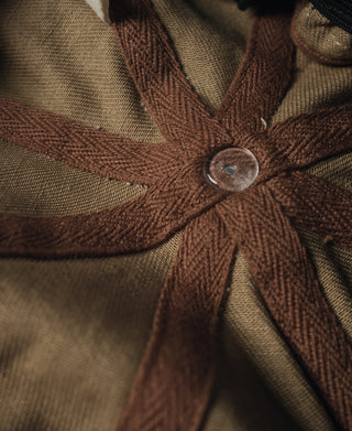 Khaki biker cap starburst patch with round metal snap at center.