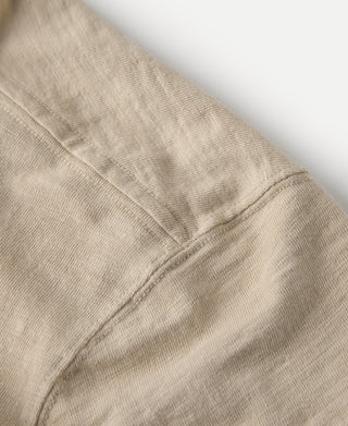Light tan T-shirt side seam and textured cotton fabric close-up