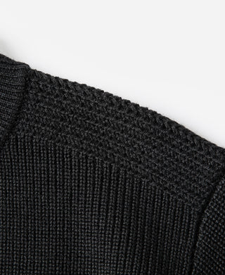 Black wool sweater knit close-up, textured fabric and shoulder seam
