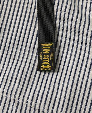 Drawstring tag on striped pants with gold text on black strap