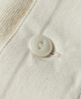 Beige henley button close-up with white snap-style closure