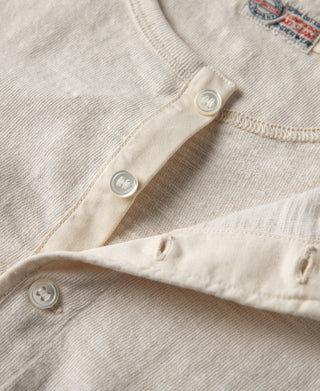 Loopwheel henley t-shirt button placket close-up with fabric stitching in apricot-beige