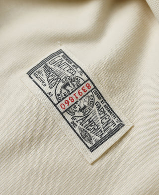 Interior label detail on a light cream henley shirt
