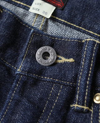 Indigo denim jeans coin pocket with engraved metal button and size label, close-up
