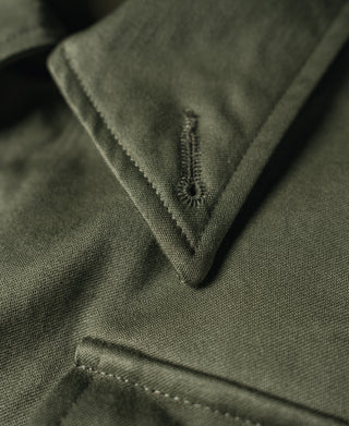Olive field jacket collar close-up with V-stitching and textured fabric