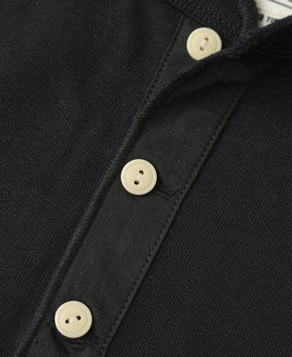 Black henley button placket detail with three cream round buttons.